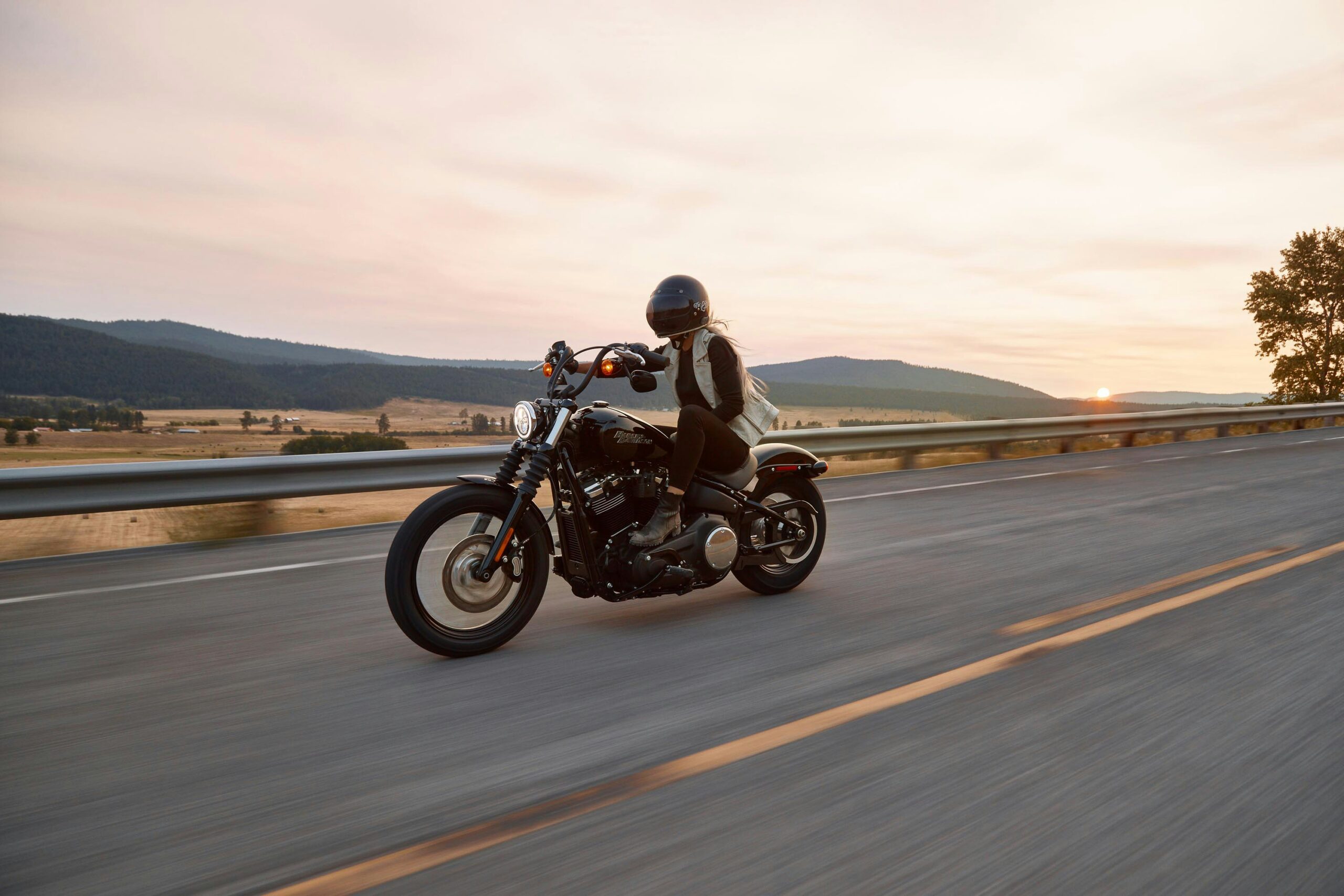 Woman riding Harley Davidson in southern California road.